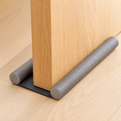 Twin-foam door draft guard installed beneath an oak door